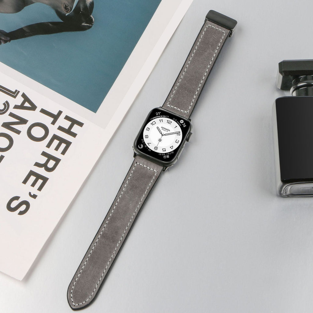 Bracelet Apple Watch en microfibre gris foncé avec coutures blanches et fermoir noir.