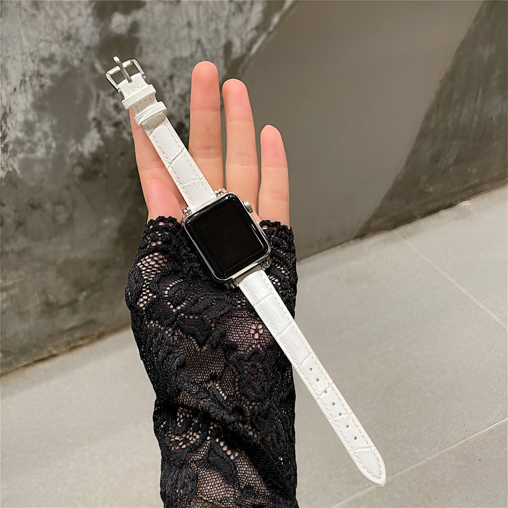 Bracelet Apple Watch blanc en microfibre avec boucle argentée, porté sur main gantée de dentelle noire.