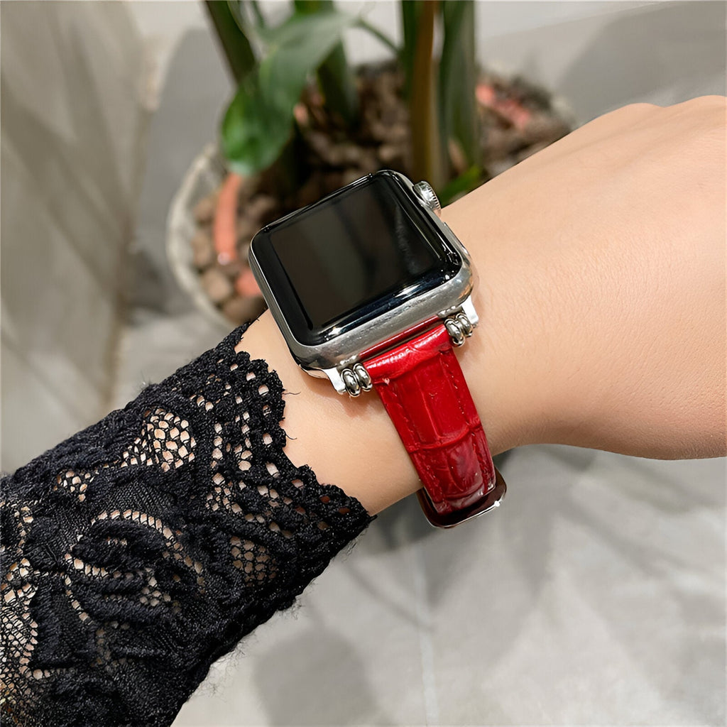 Bracelet Apple Watch rouge en microfibre effet cuir verni sur poignet féminin avec manche dentelle noire.