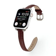 Bracelet Apple Watch en microfibre marron, fermoir argenté, couture blanche contrastée.