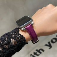 Bracelet Apple Watch microfibre violet pour femme, ajustable, style élégant, porté au poignet.