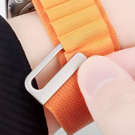Bracelet Apple Watch en nylon orange à boucle alpine argentée, style sport et ajustable.