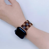 Bracelet Apple Watch en nylon à carreaux marron et beige, style mixte, porté au poignet.