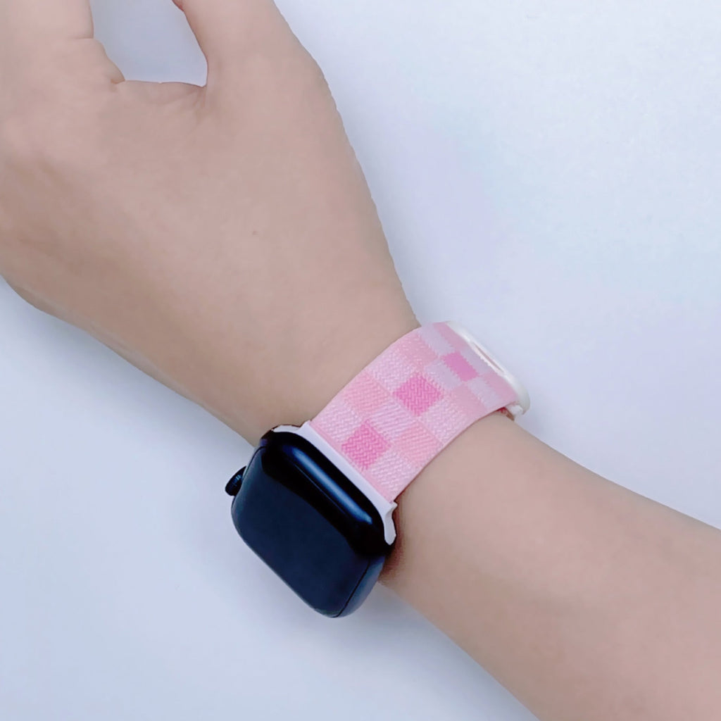 Bracelet Apple Watch en nylon rose à carreaux, modèle Kyris, porté au poignet.