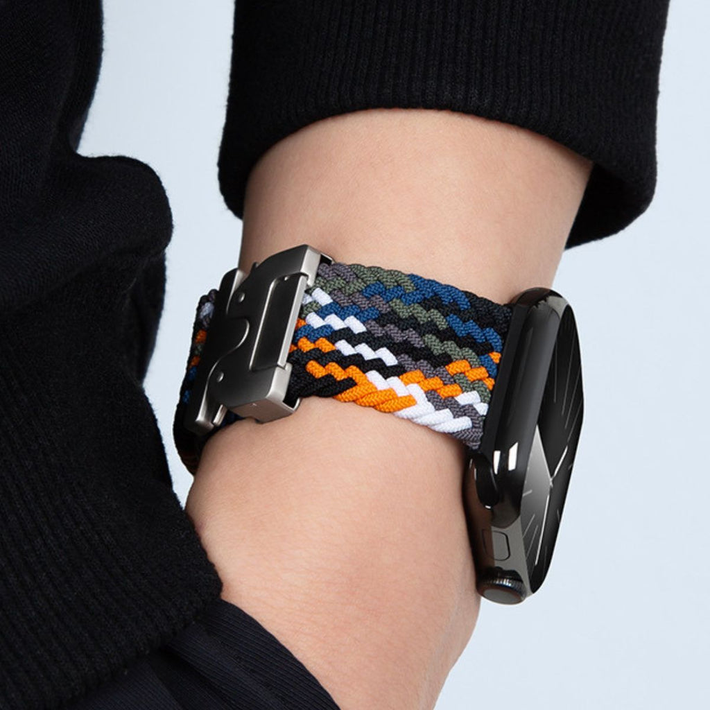 Bracelet Apple Watch en nylon tressé multicolore avec boucle tactique noire, porté au poignet.