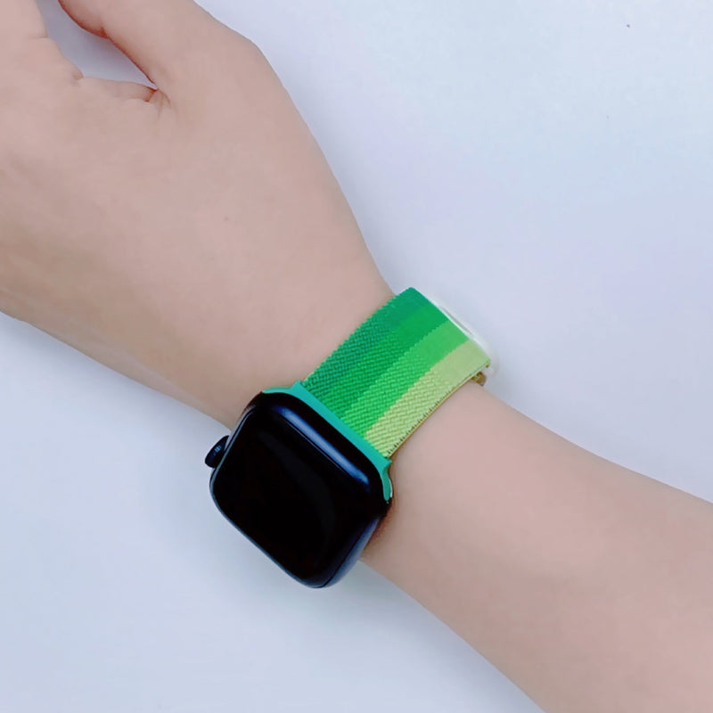 Bracelet Apple Watch en nylon dégradé vert sur poignet, modèle Fenix mixte.