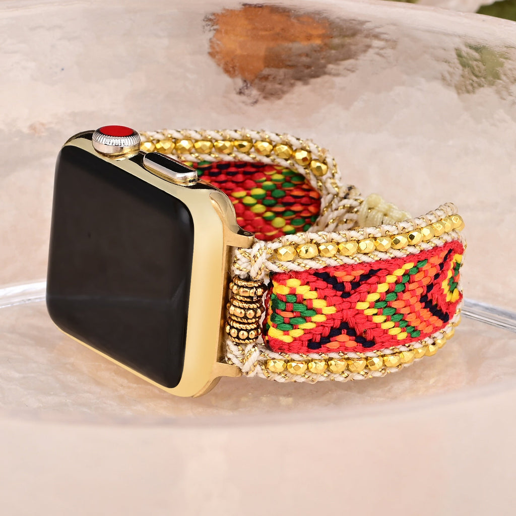 Bracelet Apple Watch en nylon rouge tissé avec motifs géométriques noirs et jaunes, bordé de perles dorées.
