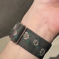 Bracelet Apple Watch en nylon noir à motif floral blanc et vert, modèle Elexia pour femme.