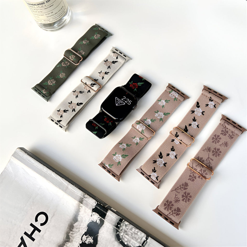 Cinq bracelets Apple Watch en nylon floral, couleurs kaki, blanc, noir et rose, avec fermoirs argentés.