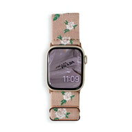 Bracelet Apple Watch en nylon rose à motifs floraux blancs et verts, boucle métallique noire.
