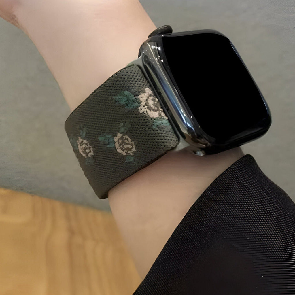 Bracelet Apple Watch en nylon kaki avec motifs floraux blancs et verts, style féminin.