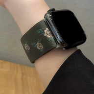 Bracelet Apple Watch en nylon kaki avec motifs floraux blancs et verts, style féminin.