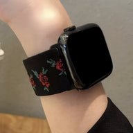 Bracelet Apple Watch en nylon noir orné de motifs floraux rouges et verts, modèle Elexia, pour femme.