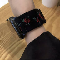Bracelet Apple Watch en nylon noir avec motif floral rouge et vert, modèle Elexia, pour femme.