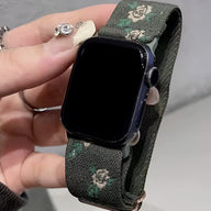 Bracelet Apple Watch en nylon kaki avec motifs floraux blancs, boucle noire élégante.