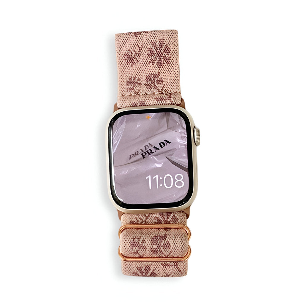 Bracelet Apple Watch en nylon rose avec motifs floraux beige et boucle dorée.