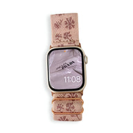 Bracelet Apple Watch en nylon rose avec motifs floraux beige et boucle dorée.
