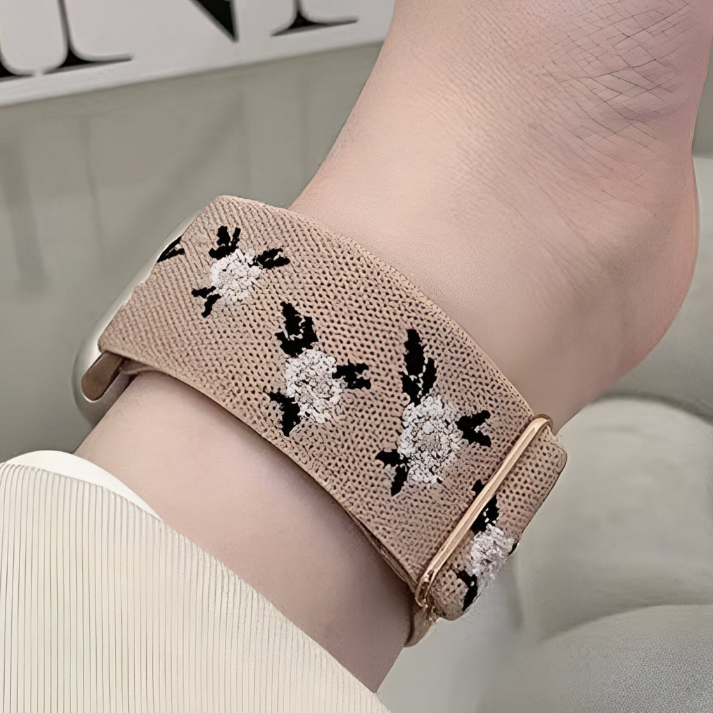 Bracelet Apple Watch en nylon beige à motifs floraux blancs et noirs, boucle dorée rose.
