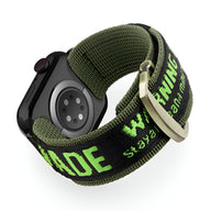 Bracelet Apple Watch en nylon vert olive avec texte jaune fluo, boucle métallique argentée.