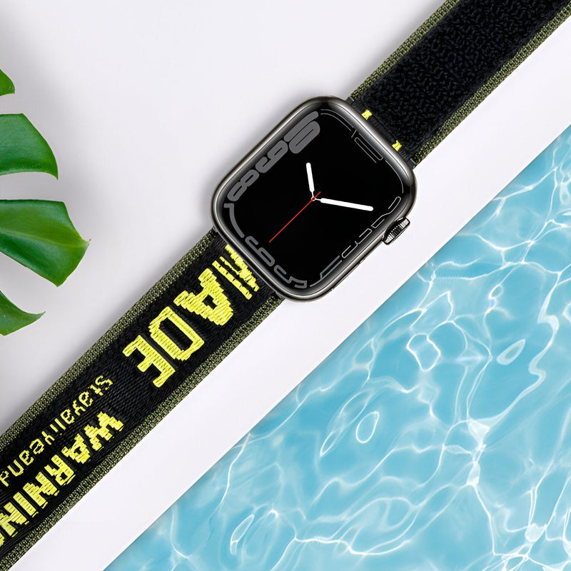 Bracelet Apple Watch nylon noir avec inscription jaune "WARNING MADE" style sport.