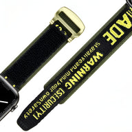 Bracelet Apple Watch noir et jaune en nylon avec texte d’avertissement et boucle métallique dorée.