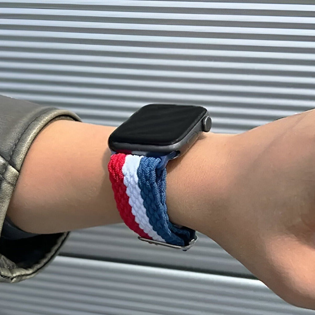 Bracelet Apple Watch en nylon tricolore bleu, blanc, rouge porté au poignet.