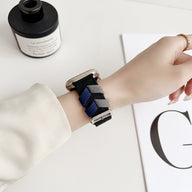 Bracelet Apple Watch en nylon bleu et noir style tressé porté au poignet.