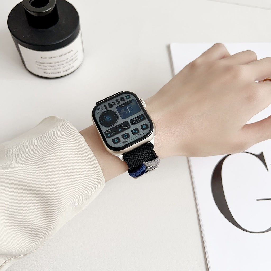 Bracelet Apple Watch en nylon noir, modèle Nari, style ajustable et unisexe portés au poignet.