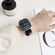 Bracelet Apple Watch en nylon noir, modèle Nari, style ajustable et unisexe portés au poignet.