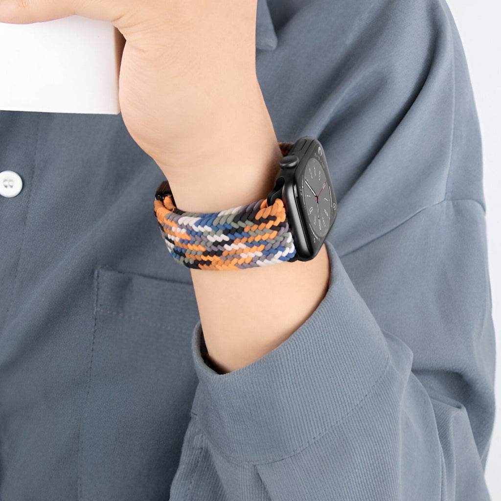 Bracelet Apple Watch en nylon multicolore orange, noir et beige, modèle Xylon, porté au poignet.