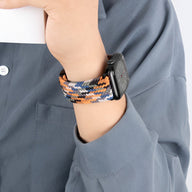 Bracelet Apple Watch en nylon multicolore orange, noir et beige, modèle Xylon, porté au poignet.