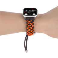 Bracelet Apple Watch en nylon marron avec détails orange, style tressé ajustable.