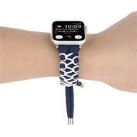 Bracelet en nylon bleu marine et blanc à motifs géométriques pour Apple Watch posé sur un poignet.