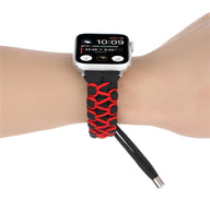 Bracelet Apple Watch en nylon noir et rouge motif tressé, ajustable, porté au poignet.