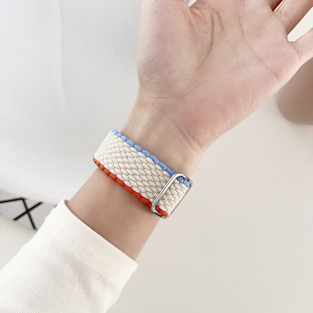 Bracelet Apple Watch en nylon blanc à motifs bleu clair et rouge, boucle argentée, pour femme.