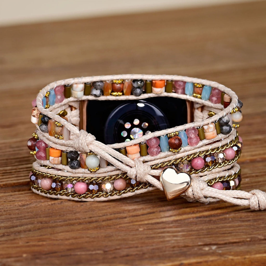 Bracelet Apple Watch pour femme en pierres de cristal multicolores avec cordon beige et pendentif cœur en métal doré.