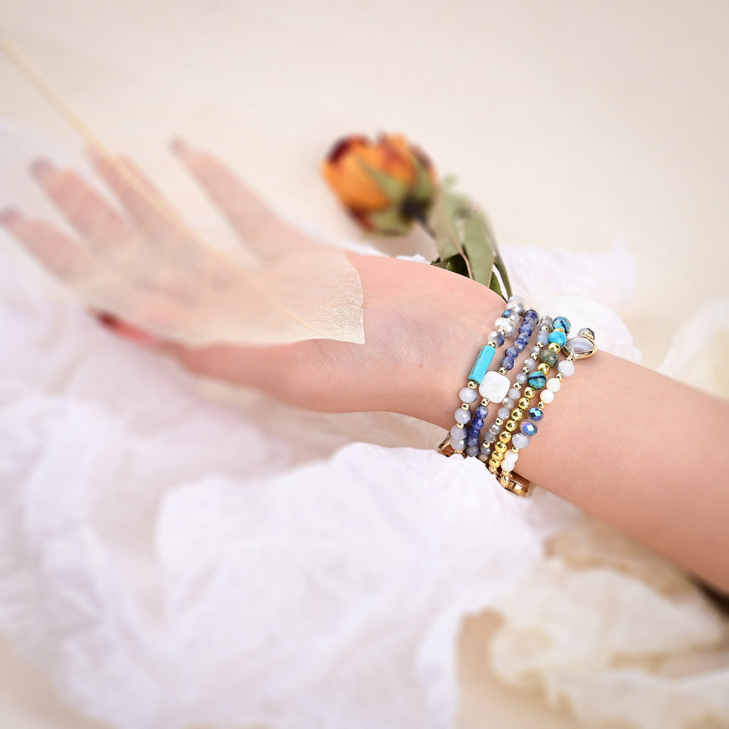 Bracelets en pierres de cristal multicolores portés avec une Apple Watch, style délicat et féminin.