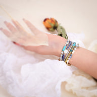 Bracelets en pierres de cristal multicolores portés avec une Apple Watch, style délicat et féminin.