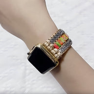 Bracelet Apple Watch multicolore en pierres de jaspe, style tressé avec perles dorées, porté au poignet.