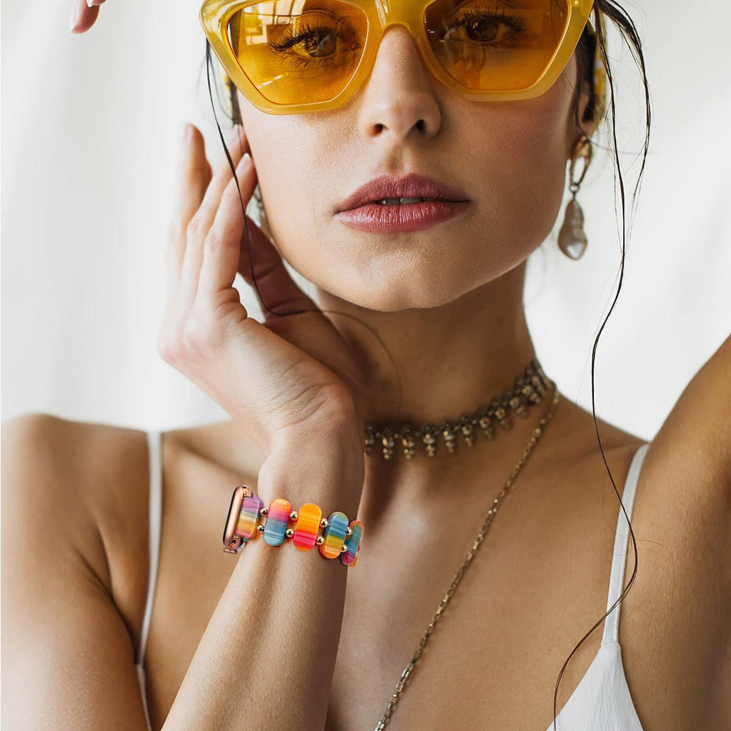 Bracelet Apple Watch en résine multicolore, style sauvage, porté sur poignet féminin.