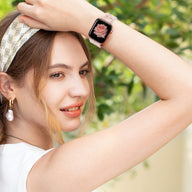 Bracelet Apple Watch en résine beige avec motif sauvage, porté au poignet d'une femme blonde à l'extérieur.