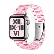 Bracelet Apple Watch en résine transparente rose avec maillons larges et fermoir métallique argenté.