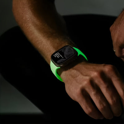 Bracelet Apple Watch en silicone blanc phosphorescent, modèle Kelan, porté au poignet homme.