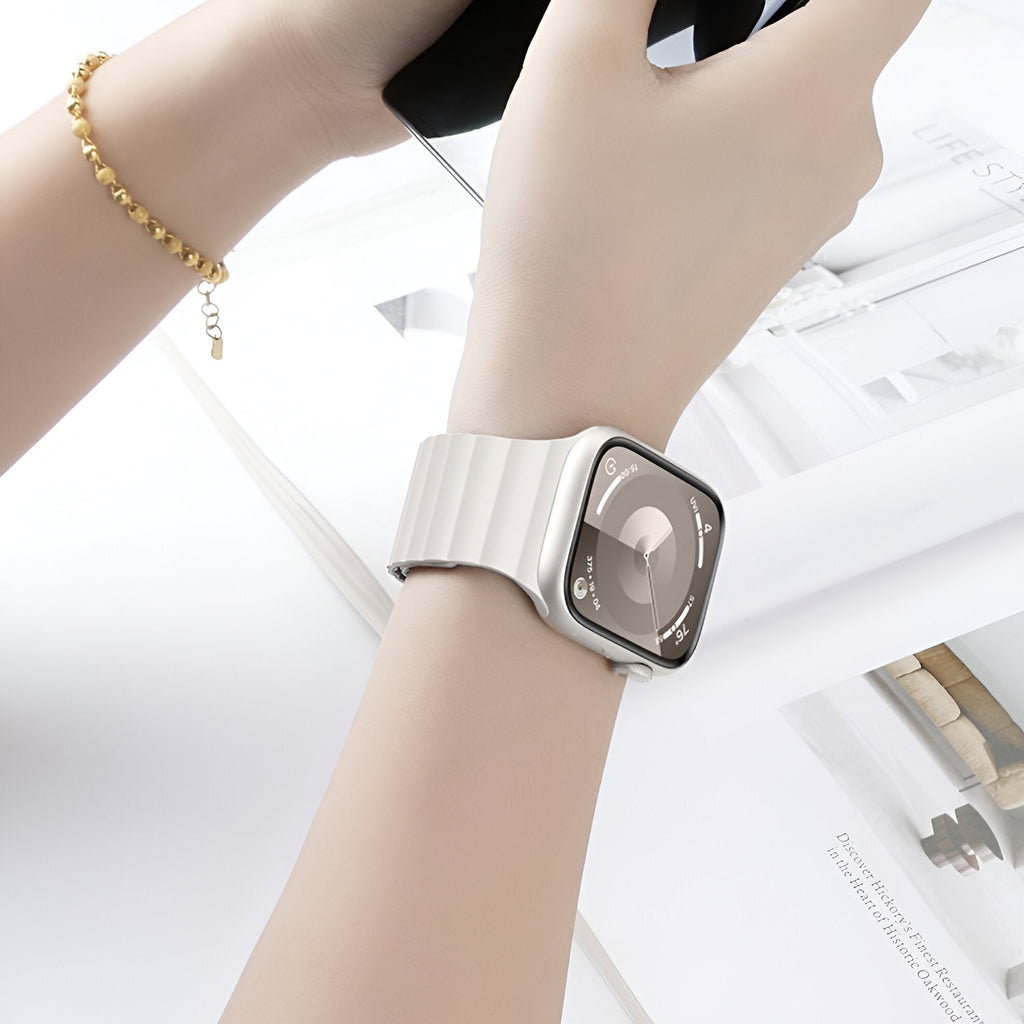 Bracelet pour Apple Watch en silicone beige clair, style sport, fermé sur un poignet féminin.