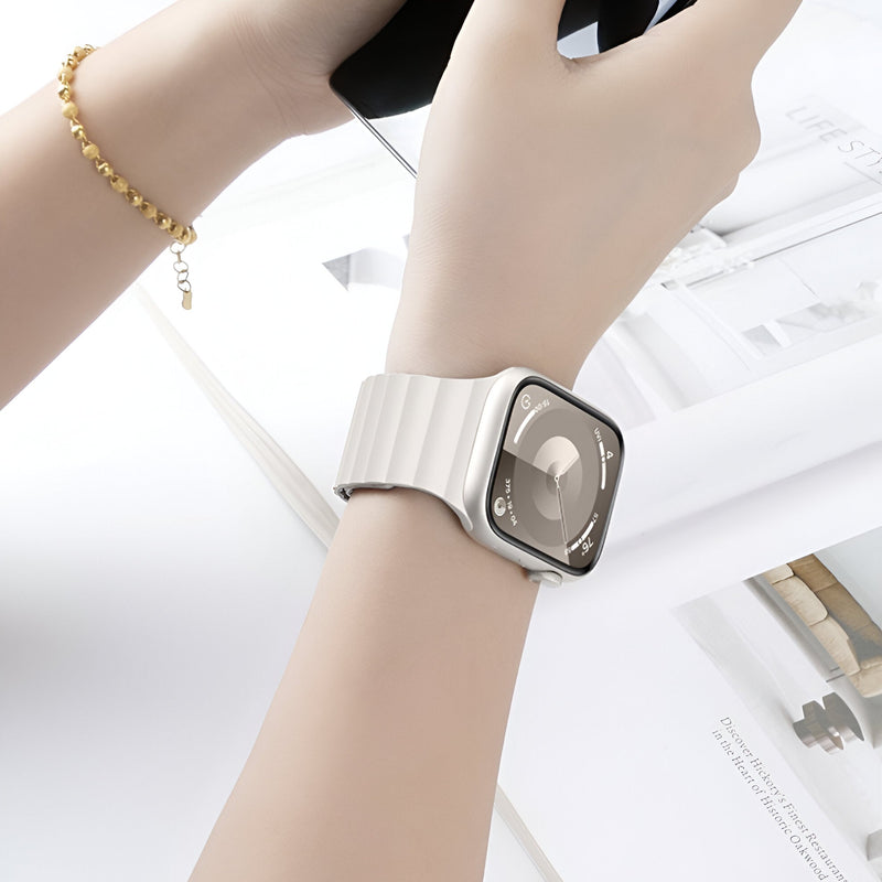Bracelet pour Apple Watch en silicone beige clair, style sport, fermé sur un poignet féminin.