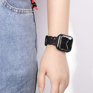 Bracelet Apple Watch silicone noir avec perforations, modèle Astra, porté au poignet féminin.