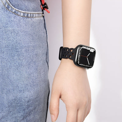 Bracelet Apple Watch silicone noir avec perforations, modèle Astra, porté au poignet féminin.