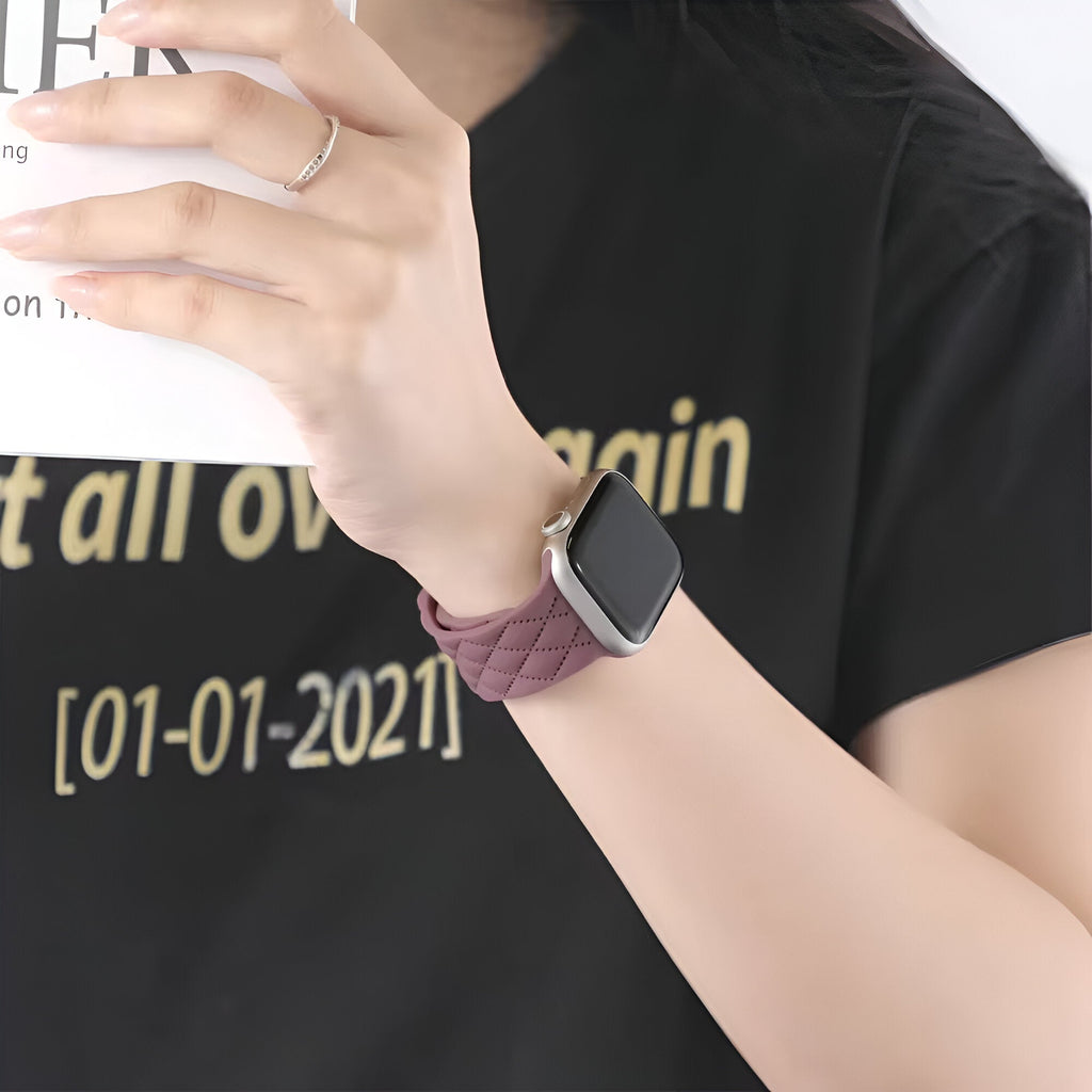 Bracelet Apple Watch en silicone pourpre tressé, ajustable, modèle Caliope, porté au poignet.