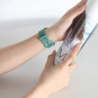 Bracelet Apple Watch en silicone vert menthe, modèle Caliope, porté au poignet, fermé par boucle classique.