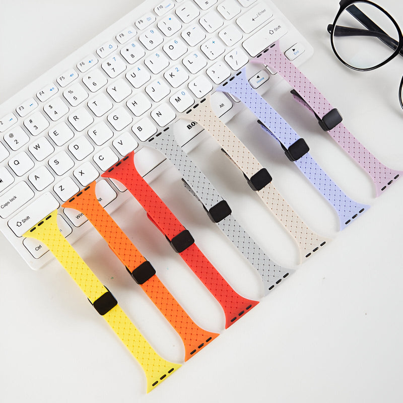 Bracelets Apple Watch en silicone à motifs perforés, dégradé de jaune à violet pâle, fermoir noir.